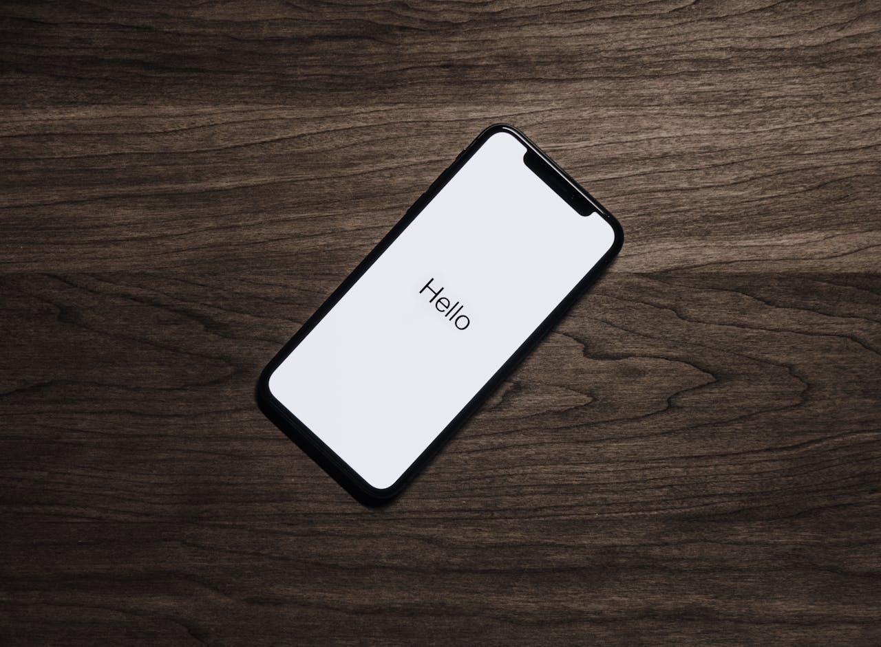 A smartphone displaying Hello on a wooden surface, showcasing modern technology.